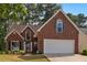 Charming brick home boasts manicured lawn and a two-car garage, framed by mature trees at 64 Harbour Lake Dr, Fayetteville, GA 30215