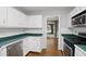 Well-lit kitchen featuring white cabinets, stainless steel appliances and a view to the backyard at 64 Harbour Lake Dr, Fayetteville, GA 30215