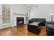 Comfortable living room boasts a fireplace with a black hearth and hardwood flooring at 64 Harbour Lake Dr, Fayetteville, GA 30215