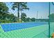 A close-up view shows a fenced-in tennis court with green and blue surfaces at 64 Harbour Lake Dr, Fayetteville, GA 30215