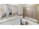 Bright bathroom featuring a white vanity with gold fixtures and a shower with gold frame at 9005 Old Southwick Pass, Alpharetta, GA 30022