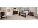 Carpeted bedroom featuring an ornate wood bed frame and classic furniture at 9005 Old Southwick Pass, Alpharetta, GA 30022