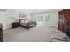 Large carpeted bedroom with natural light and a sleigh bed with coordinating wooden furniture at 9005 Old Southwick Pass, Alpharetta, GA 30022