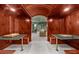Wood-paneled game room with card tables and marble tops leads to a comfortable lounge area at 9005 Old Southwick Pass, Alpharetta, GA 30022