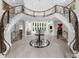 A grand foyer features marble floors, a curved staircase, and an open view to the formal living area at 9005 Old Southwick Pass, Alpharetta, GA 30022