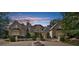 An elegant exterior view of a two-story home featuring a circular driveway and a decorative fountain at 9005 Old Southwick Pass, Alpharetta, GA 30022