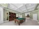 A well-lit game room features a pool table, a built-in bar with seating and ample space at 9005 Old Southwick Pass, Alpharetta, GA 30022