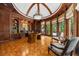 A luxurious home office features wood paneling, built-in bookshelves, and a large desk under a dome ceiling at 9005 Old Southwick Pass, Alpharetta, GA 30022