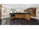 Kitchen island with black granite countertops, hardwood cabinets and decorative lighting at 9005 Old Southwick Pass, Alpharetta, GA 30022