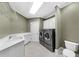 Laundry room equipped with modern washer and dryer, ample counter space, and sink at 9005 Old Southwick Pass, Alpharetta, GA 30022