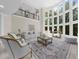 An elegant living room features a high ceiling, large windows, and neutral decor at 9005 Old Southwick Pass, Alpharetta, GA 30022