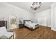 Spacious main bedroom featuring a hardwood floor, a decorative ceiling, and a chandelier at 9005 Old Southwick Pass, Alpharetta, GA 30022