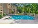 Beautiful backyard pool with tiled deck, an outdoor dining area, and lush, mature landscaping at 9005 Old Southwick Pass, Alpharetta, GA 30022