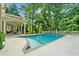 Beautiful backyard pool with tiled deck, an outdoor dining area, and lush, mature landscaping at 9005 Old Southwick Pass, Alpharetta, GA 30022