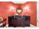 Elegant powder room with a dark wood vanity, granite countertop, and decorative mirror at 9005 Old Southwick Pass, Alpharetta, GA 30022