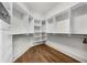 Walk-in closet featuring wood floors, custom shelving and drawers at 9005 Old Southwick Pass, Alpharetta, GA 30022