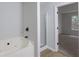 Bathroom featuring a soaking tub with tile surround, a separate shower, and modern fixtures at 450 Pinevale Ct, Atlanta, GA 30349