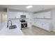 Modern kitchen with white cabinets, stainless steel appliances, and light wood-look flooring at 450 Pinevale Ct, Atlanta, GA 30349