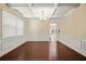 Formal dining room with wainscoting, coffered ceiling, chandelier, and hardwood flooring at 4540 Fourth Rail Ln, Cumming, GA 30040