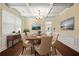 Dining room with decorative coffered ceiling, wainscoting, wood floors, and elegant furniture at 4540 Fourth Rail Ln, Cumming, GA 30040