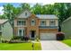 Charming two-story home featuring a brick facade, well-manicured lawn, and attached two-car garage at 4540 Fourth Rail Ln, Cumming, GA 30040