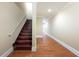 Hallway featuring hardwood floors, stairs, and white trim at 4540 Fourth Rail Ln, Cumming, GA 30040