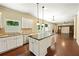 Open kitchen with granite countertops, stainless steel appliances, central island, and hardwood floors at 4540 Fourth Rail Ln, Cumming, GA 30040