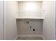 Bright laundry room with tile floor, wire shelving, and utility connections at 4540 Fourth Rail Ln, Cumming, GA 30040