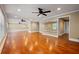 Open floor plan with hardwood floors, three ceiling fans, and a large mirror at 4540 Fourth Rail Ln, Cumming, GA 30040