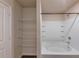 Bright bathroom featuring a tub shower, white tile surround, and built-in shelves for toiletries at 513 Moline Way, Locust Grove, GA 30248
