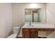 Bathroom with a toilet, a modern vanity, and a large mirror reflecting the bathtub and shower at 513 Moline Way, Locust Grove, GA 30248