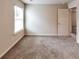 Bright bedroom with neutral carpet, a large window, and white trim and doors at 513 Moline Way, Locust Grove, GA 30248