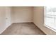 Well lit bedroom featuring neutral color walls and carpet and bright window at 513 Moline Way, Locust Grove, GA 30248
