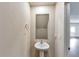 Cozy half bathroom featuring a pedestal sink, mirror, and convenient access to the main living area at 513 Moline Way, Locust Grove, GA 30248