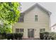 Back exterior view of home with light yellow siding, sliding glass door, and green landscaping at 847 Ashley Ln, Stone Mountain, GA 30087