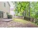 View of backyard with patio and mature trees, surrounded by a wooden fence at 847 Ashley Ln, Stone Mountain, GA 30087