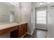 Light-filled bathroom featuring a large vanity, mirror, and natural light from a window at 847 Ashley Ln, Stone Mountain, GA 30087