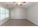 Spacious bedroom features neutral carpet, a ceiling fan and natural light from large window at 847 Ashley Ln, Stone Mountain, GA 30087