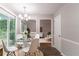 Bright dining room with glass table, white chairs, and sliding glass doors to the backyard at 847 Ashley Ln, Stone Mountain, GA 30087