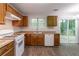 Kitchen featuring wood cabinets, white appliances, and a view to the backyard at 847 Ashley Ln, Stone Mountain, GA 30087