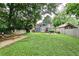 Expansive backyard with lush greenery, stone wall, and a cozy firepit seating area, perfect for outdoor entertaining at 1136 Moreland Se Pl, Atlanta, GA 30316