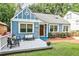 Blue home featuring a charming covered porch, complemented by a lush, green lawn at 1136 Moreland Se Pl, Atlanta, GA 30316