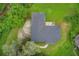 Aerial view of property with dark roof, patio area, green lawn, trees, and small creek in natural setting at 1740 Dodson Sw Dr, Atlanta, GA 30311