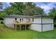 Backyard view of a two-story home, with a deck overlooking lush greenery and a well-maintained lawn at 1740 Dodson Sw Dr, Atlanta, GA 30311