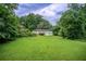 View of the home's backyard featuring a lawn and an open deck, surrounded by trees in a lush, green setting at 1740 Dodson Sw Dr, Atlanta, GA 30311
