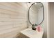 Modern powder room with shiplap wall, vanity, and oval mirror at 1740 Dodson Sw Dr, Atlanta, GA 30311