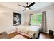 Cozy bedroom featuring a ceiling fan, large window, and stylish decor at 1740 Dodson Sw Dr, Atlanta, GA 30311