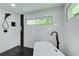 Walk-in shower features black fixtures and herring bone tile accents next to a white soaking tub and window at 1740 Dodson Sw Dr, Atlanta, GA 30311