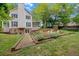 Spacious backyard with a well-maintained garden and a charming two-story home in the background at 201 Tweed Ct, Sugar Hill, GA 30518