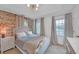 Bright bedroom with exposed brick, updated lighting, and hardwood floors at 201 Tweed Ct, Sugar Hill, GA 30518